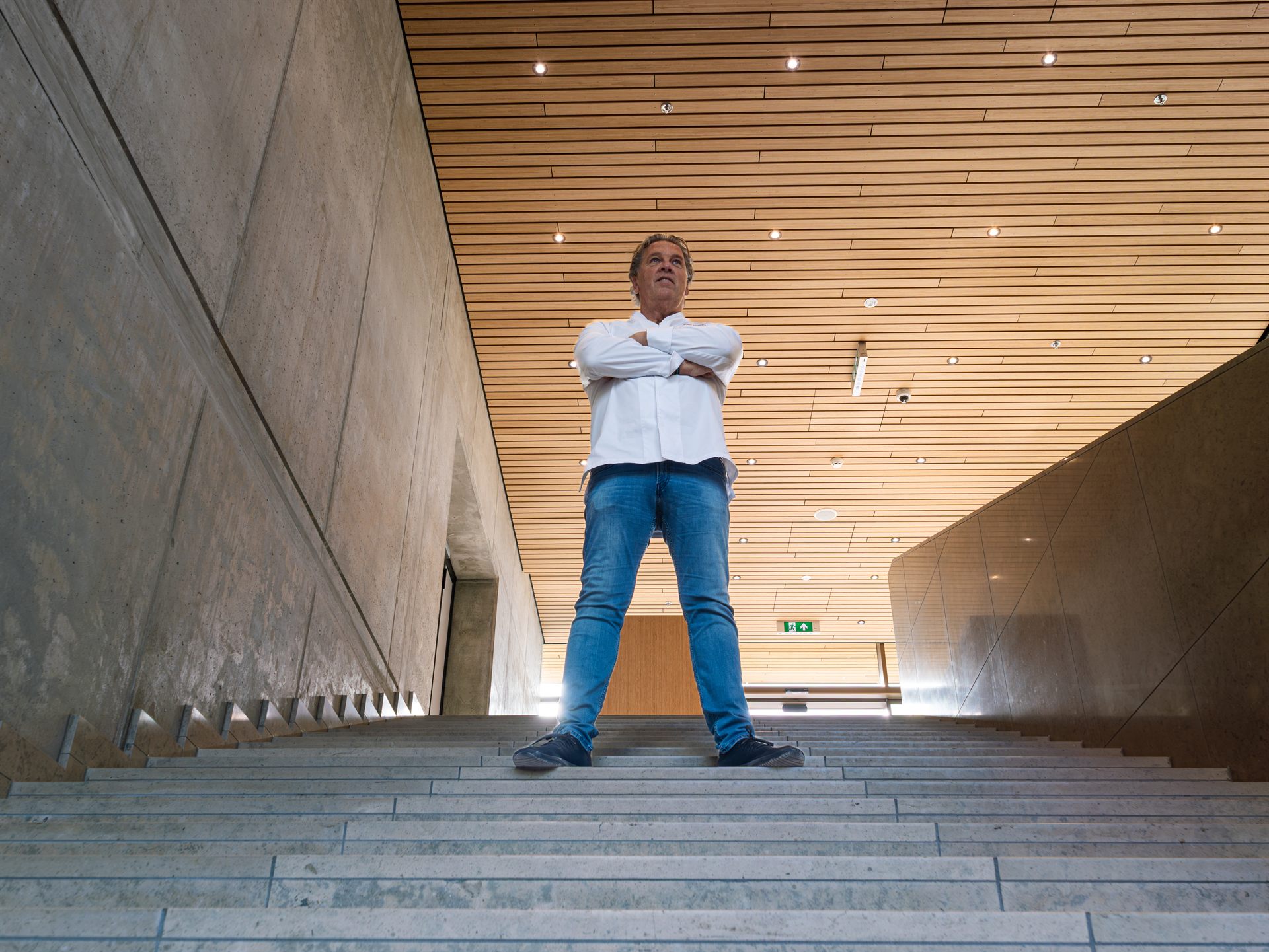 Man poseert op de trap in het moderne interieur van Restaurant Fred tijdens de verbouwing.